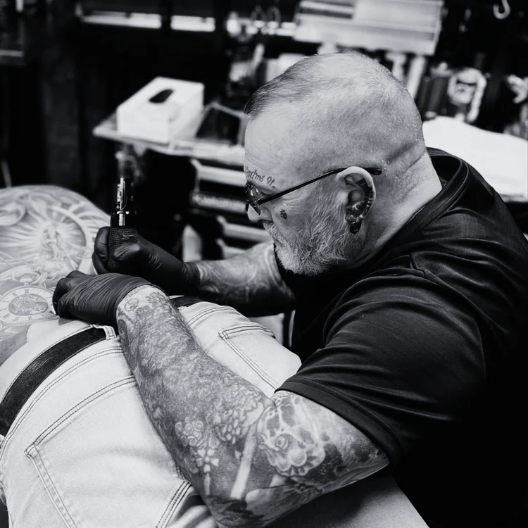 Tattoo artist creating a large back tattoo inside Jinked tattoo studio in Porthcawl.